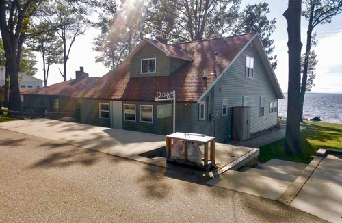 Prudenville House | New Listing! Lake front cottage with 100' of private sandy beach